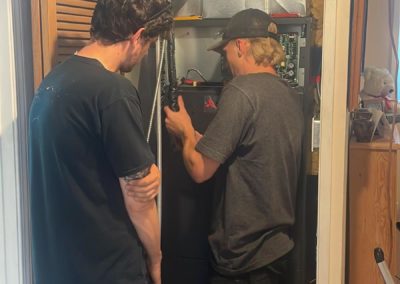 ServiceXCEL techs working inside closet hot water tank